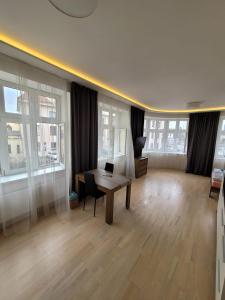 een woonkamer met een tafel, stoelen en ramen bij Skořepka15 apartment Brno-střed in Brno