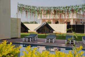 uma tenda com mesas e cadeiras ao lado de uma piscina em Omak Tiger Seven em Sawai Madhopur
