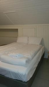 a large white bed with white sheets and pillows at Apt. 301 - Andenes Whale Safari Apartments in Andenes
