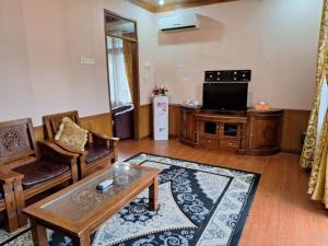 sala de estar con sofá y TV en Mifan Resort And Water Park en Padangpanjang