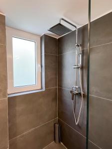 a shower in a bathroom with a window at 3 Bedroom Apartment Near Flisvos in Athens