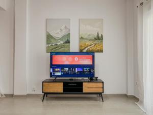 einen Flachbild-TV auf einem Stand in einem Zimmer in der Unterkunft 3 Bedroom Apartment Near Flisvos in Athen