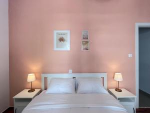 1 dormitorio con 1 cama blanca y 2 lámparas en 3 Bedroom Apartment Near Flisvos, en Atenas