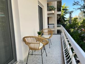 two chairs and a table on a balcony at 3 Bedroom Apartment Near Flisvos in Athens