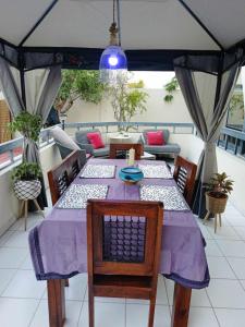 Jumeirah Beach Villa في دبي: طاولة مع قطعة قماش أرجوانية على شرفة