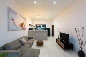 a living room with a couch and a tv at Deby Villa Seminyak in Seminyak
