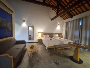 um quarto de hotel com duas camas e um sofá em Hoi An Ancient House Resort & Spa em Hoi An