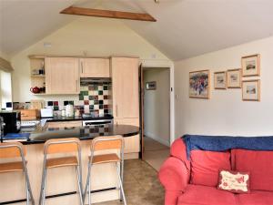 a living room with a red couch and a kitchen at 2 Bed in Stratford-upon-Avon CC025 in Ilmington