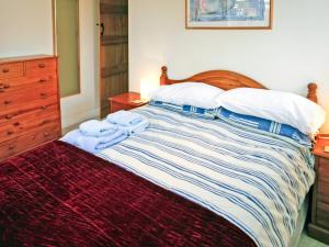 a bedroom with a bed with a wooden headboard and pillows at 2 Bed in Stratford-upon-Avon CC025 in Ilmington
