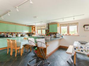 a kitchen with green cabinets and a table and chairs at 6 Bed in Woodstock CC028 in Stonesfield