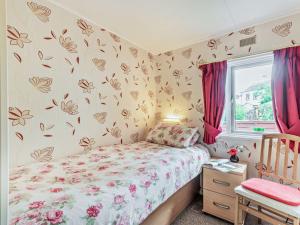 a small bedroom with a bed and a window at 3 Bed in Cockermouth 49198 in Cockermouth