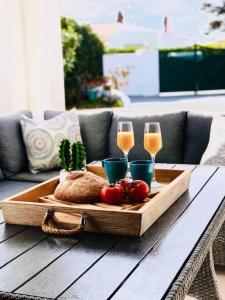 een dienblad met twee glazen champagne en tomaten op een tafel bij Villa León Menorca in Cala'n Bosch