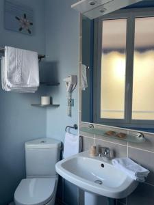 a bathroom with a white toilet and a sink at Hôtel de la Plage in Fécamp