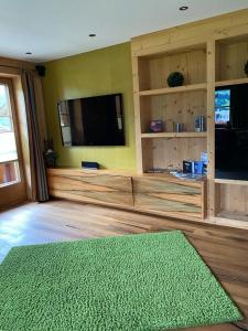 斯圖姆的住宿－Appartement Pargger，客厅配有平面电视和绿色地毯。
