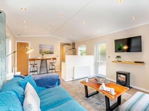 a living room with a blue couch and a table at 1 Bed in Coniston Water 50081 in High Nibthwaite