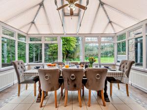 a dining room with a table and chairs and windows at 4 bed in Cromford 52094 in Highpeak Junction