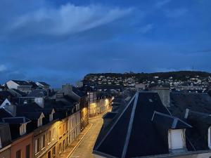 vistas a una ciudad por la noche con edificios en Hôtel de la Plage, en Fécamp