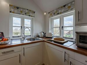 a kitchen with a sink and two windows at 1 bed in Wittersham 49942 in Wittersham