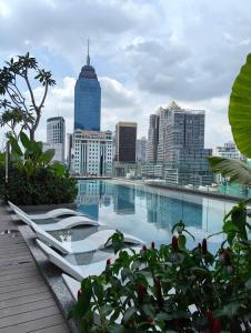 a swimming pool with a city skyline in the background at Quill Residences Suites Kuala Lumpur in Kuala Lumpur