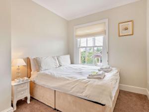 a white bedroom with a bed and a window at 3 Bed in Gillingham 53854 in Gillingham