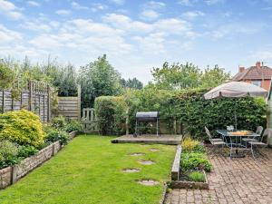 a garden with a table and an umbrella at 3 Bed in Gillingham 53854 in Gillingham