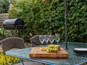 una tavola con bicchieri da vino e uva su un tagliere di 3 Bed in Gillingham 53854 a Gillingham