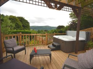 a hot tub on a wooden deck with a hot tub at 1 Bed in Gilwern 52882 in Gilwern