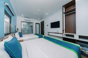 um quarto com 2 camas e uma televisão de ecrã plano em TOMMY HOTEL em Ilha de Cát Bà