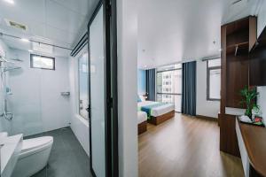 uma casa de banho com WC e um quarto com cama em TOMMY HOTEL em Ilha de Cát Bà