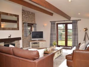 uma sala de estar com um sofá e uma televisão em 2 Bed in Bath 56550 em Stowey