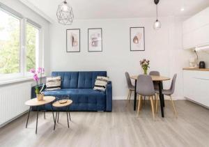 a living room with a blue couch and a table at Loft Apartments in Gdańsk