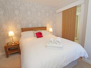 a bedroom with a white bed with two towels on it at 1 Bed in Nr Hexham CN196 in Wall