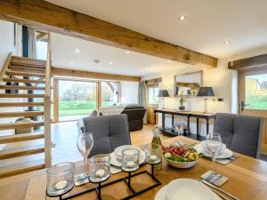 a dining room with a table with a bowl of fruit and wine glasses at 1 Bed in Dulverton 59339 in Knowstone