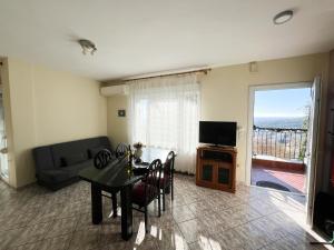 een woonkamer met een tafel, een bank en een televisie bij Nitsa Apartment in Kavala
