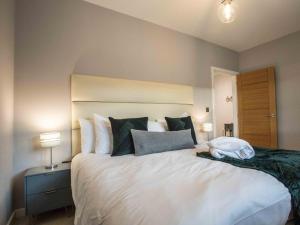 una camera da letto con un grande letto bianco con cuscini di 3 Bed in Westward Ho 60264 a Westward Ho