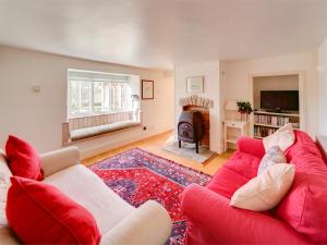 uma sala de estar com um sofá vermelho e uma lareira em 3 bed property in Isle of Purbeck Dorset IC001 em Corfe Castle
