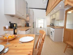 a kitchen with a wooden table with a bowl of fruit on it at 1 Bed in Porthgain 61170 in Porthgain
