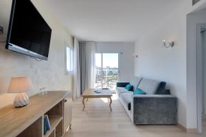 a living room with a couch and a flat screen tv at Cala Millor Garden Hotel - Adults Only in Cala Millor
