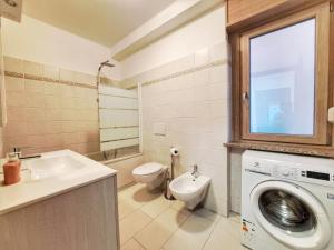 een badkamer met toilet, wastafel en wasmachine bij Casa Alpina - Appartamento Aosta in Aosta