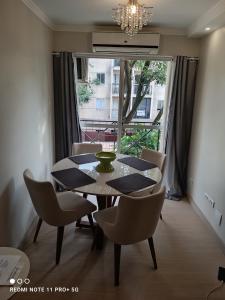 Apartamento Aconchegante في فوز دو إيغواسو: غرفة طعام مع طاولة وكراسي ونافذة
