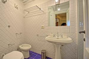 a bathroom with a sink and a toilet and a mirror at Montegufoni by PosarelliVillas in Montagnana Val di Pesa