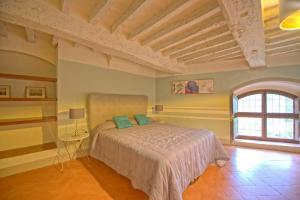 a bedroom with a bed and a large window at Montegufoni by PosarelliVillas in Montagnana Val di Pesa