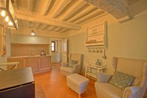 a large living room with chairs and a table at Montegufoni by PosarelliVillas in Montagnana Val di Pesa