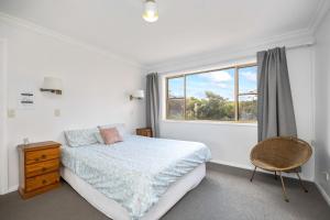 1 dormitorio con cama y ventana en Rennies Beach Escape "Carinya", en Ulladulla