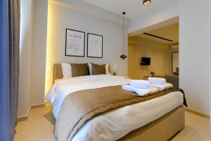 a bedroom with a large bed with towels on it at Luxury Super Central Apartment 2 in Larisa
