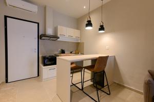 a kitchen with a counter and chairs in a room at Luxury Super Central Apartment 2 in Larisa