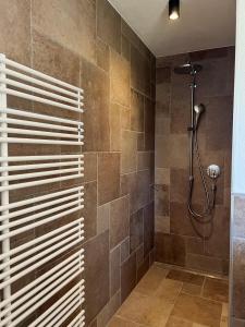 a bathroom with a shower with brown tiles at Landhaus Huber in Fügen