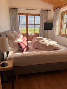 a bed with pillows and a window in a room at Landhaus Huber in Fügen