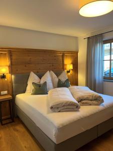 1 dormitorio con 1 cama blanca grande con almohadas en Landhaus Huber, en Fügen