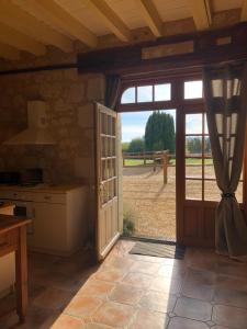 eine offene Tür zu einer Küche mit Blick auf ein Feld in der Unterkunft Logis de Poëllier in Baugé
